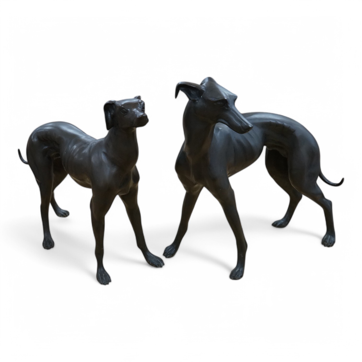 A pair of modern bronze greyhounds, approximately 66cm wide x 53cm high and 49cm wide x 57cm high. Condition - good